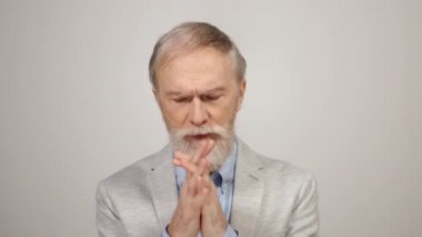 Evde dua eden stresli bir adam. Stüdyo geçmişinde el sıkışan yaşlı üzgün adam..