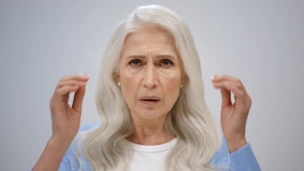 Een gestresste vrouw met hoofdpijn binnenshuis. Senior dame die lijdt aan pijn van binnen. — Stockvideo