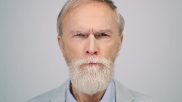 Serious man squinting eyes in studio. Senior gentleman looking camera indoors. — Stock Video