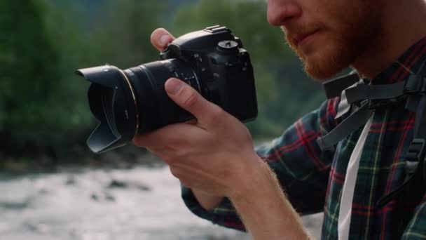 Vážný muž přizpůsobuje zoom objektivu kamery. Fotograf fotografující před kamerou — Stock video