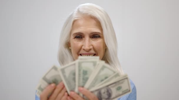 Багата літня жінка рахує гроші в студії. Успішна леді тримає готівку в приміщенні . — стокове відео