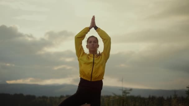 Ung dam som utför yoga i trädposen. Atletisk tjej som gör yoga i bergen — Stockvideo