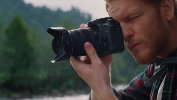 Facet robi zdjęcia aparatem fotograficznym. mężczyzna turysta dostosowanie zoom na obiektyw kamery — Wideo stockowe