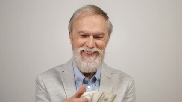 Boldog öregember, aki bent számolja a pénzt. Gazdag fickó kezében dollár a modern stúdióban. — Stock videók