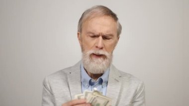 Yaşlı adam içeride para sayıyor. Zengin yaşlı işadamı stüdyoda para alıyor..