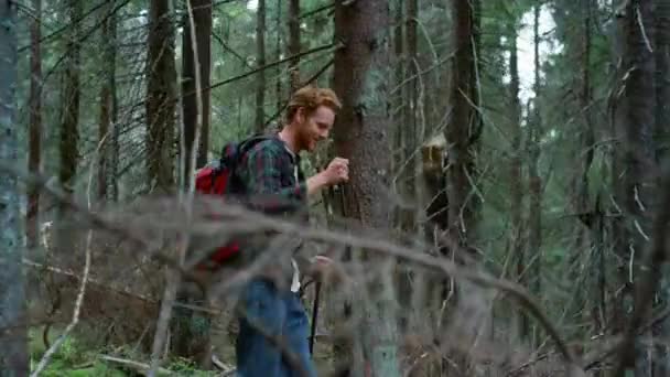 Улыбающийся парень ходит по лесу в летнее время. Счастливый поход в зеленый лес — стоковое видео