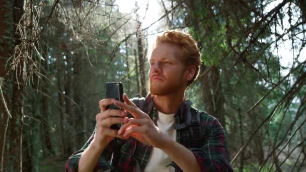 Ο άνθρωπος που παίρνει φωτογραφίες σε smartphone στο δάσος. Τύπος που χρησιμοποιεί κινητό τηλέφωνο στο δάσος. — Αρχείο Βίντεο