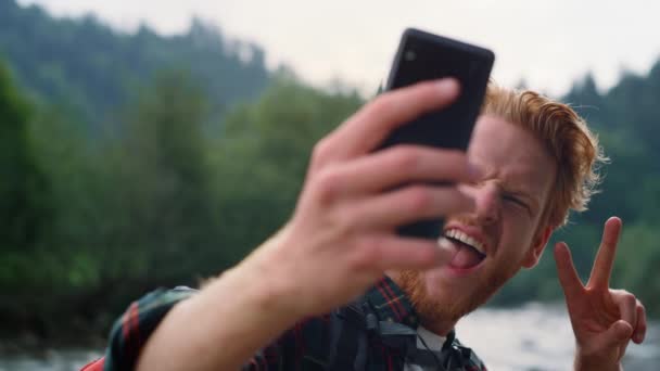 Randonneur prenant selfie au téléphone dans le paysage de montagne. Homme montrant signe de paix — Video