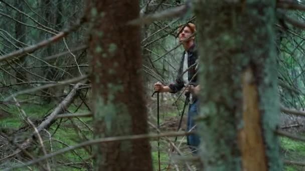 Uomo con zaino trekking nel verde dei boschi. Un ragazzo sorridente si ferma a riposare dopo l'escursione — Video Stock
