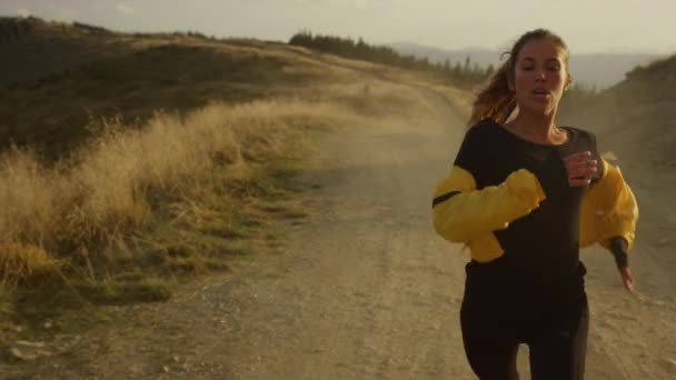 Fit meisje loopt marathon in het berglandschap. Moe jogger stoppen na het hardlopen — Stockvideo