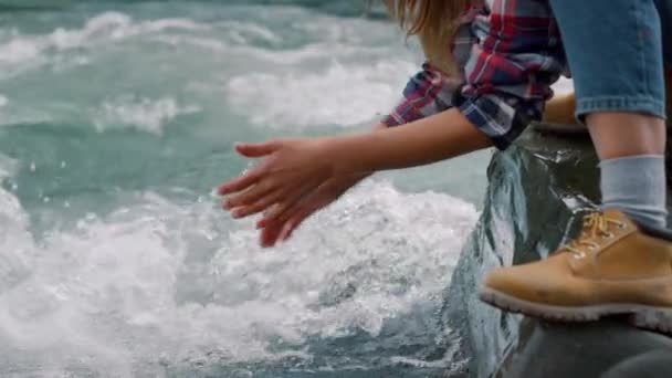 Vrouw handen die water aanraken in de rivier. Toeristisch spetterend water in de lucht van de beek — Stockvideo