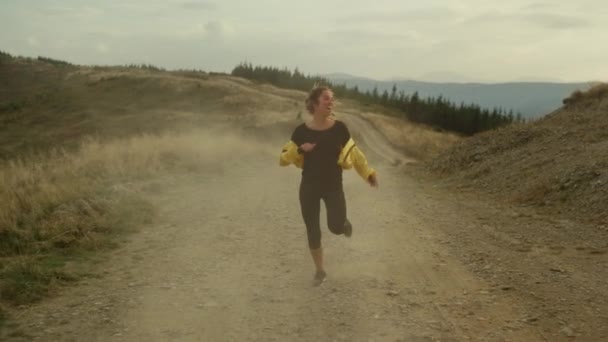 Kobieta biegająca w górach. Szczęśliwy sportowiec cieszący się dobrymi wynikami po treningu — Wideo stockowe