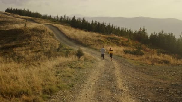 Sportsman et sportive faisant du jogging en montagne. Jeune couple exerçant en plein air — Video