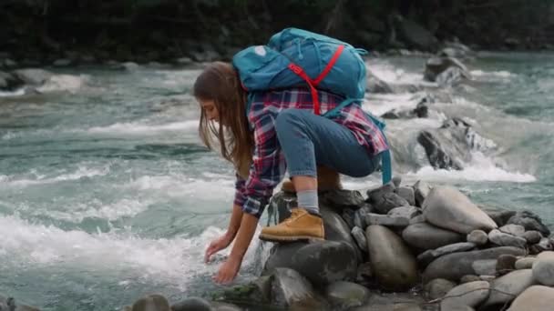 Turista tocando água no rio. Mulher cansada bebendo água doce do córrego — Vídeo de Stock