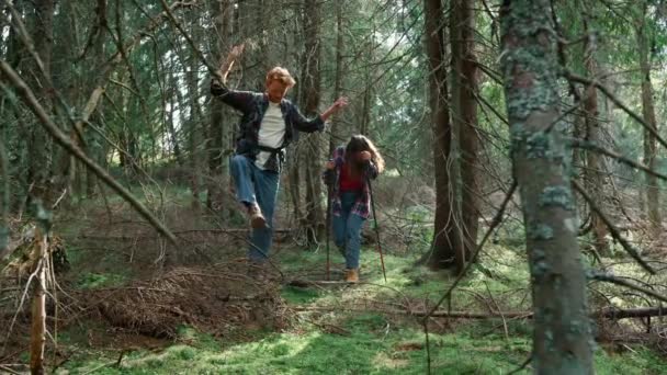 Homme et femme marchant dans une forêt de contes de fées. Randonneurs souriants marchant dans les bois verts — Video