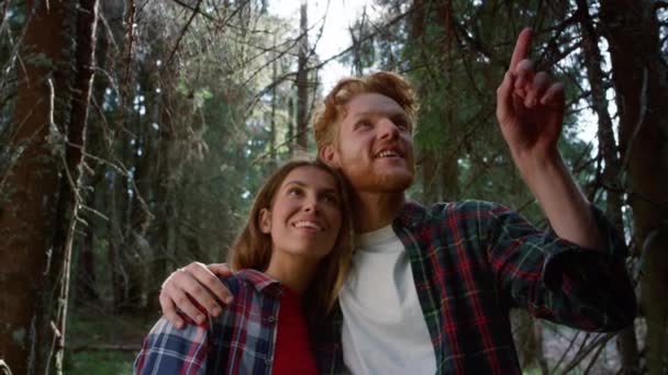 Un par abrazándose en el bosque de cuento de hadas. Turistas sonrientes tomando un descanso durante la caminata — Vídeo de stock