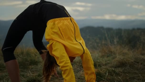Kobieta uprawiająca jogę mostkową. Sportowa dziewczyna rozciągająca się w górach — Wideo stockowe