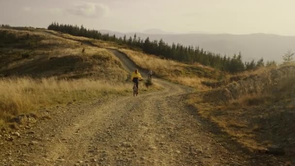 Mujer montada en bicicleta por el camino de montaña. Pareja de ciclistas entrenando juntos — Vídeo de stock