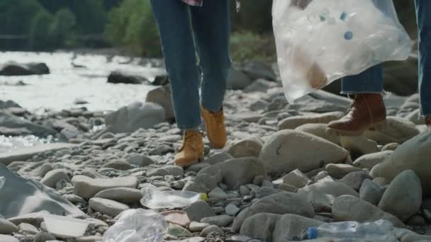 Γυναίκα και άντρας μαζεύουν μπουκάλια στο ποτάμι. Εθελοντές που συλλέγουν απόβλητα για ανακύκλωση — Αρχείο Βίντεο