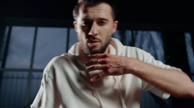 Karanlık salonda dans eden yakışıklı adam. Sokak dansçısı hareketler yapıyor..