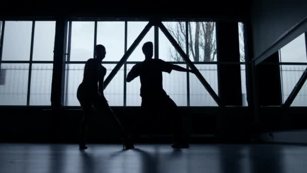 Bailarines de silueta realizando hip hop en estudio oscuro. Chico y chica bailando . — Vídeos de Stock