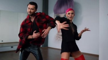 İnsanlar stüdyoda hip hop dansı yapıyor. Güzel dansçılar kamera için hareket ediyorlar..
