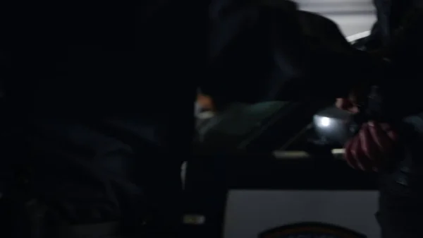 Gliniarz skuwający przestępcę w radiowozie. Policjant prowadzący przestępcę do samochodu — Zdjęcie stockowe