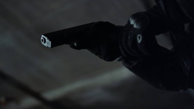 Eldivenli katil şarjörü dolduruyor. Asker tabancaya şarjör takıyor