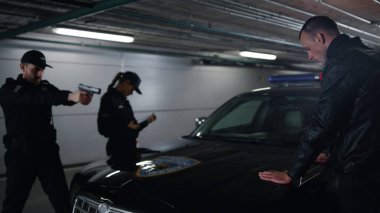 Polis memurları soyguncuyu tutukluyor. Devriye arabasında el ele tutuşan tehlikeli bir adam.