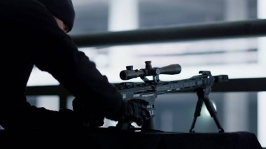 Katil saldırı tüfeği pozisyonunda. Hitman teleskopik görüşlü tüfek kullanıyor.