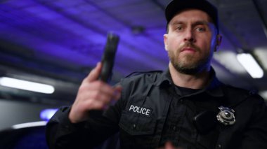 Polis silahla ateş ediyor. Erkek polis kameraya silah doğrultuyor