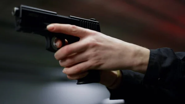 Poliskvinna skjuter med laddat vapen. Polis håller fingret på avtryckaren av pistolen — Stockfoto