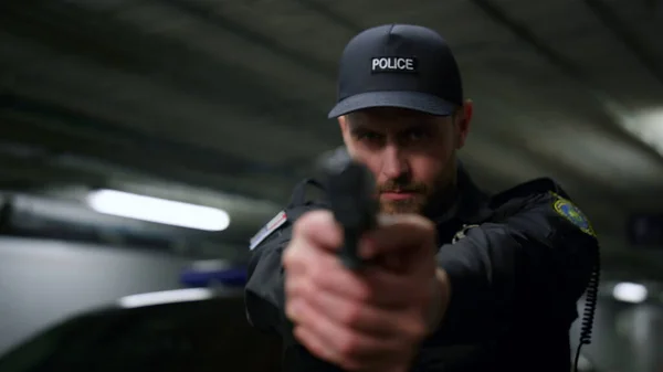 Policeman aiming gun during operation. Male cop with firearm posing at camera — Stock Photo, Image