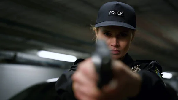 Poliskvinna siktar mot kameran. Polisskjutning med skjutvapen — Stockfoto
