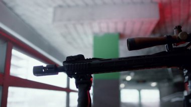 Keskin nişancı tüfekle ateş etmeye hazırlanıyor. İnşaat alanında şarj olan bir adam