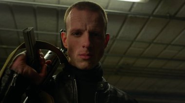 Suçlu, saldırı tüfeğiyle kameraya poz veriyor. Erkek soyguncu modern silah taşıyor.