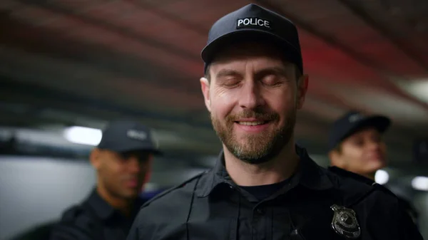 Police officer smiling at camera. Male cop wearing cap and police uniform