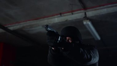 Özel harekat iştirakçisi ateşli silahı hedefliyor. SWAT askeri silahtan ateş ediyor.