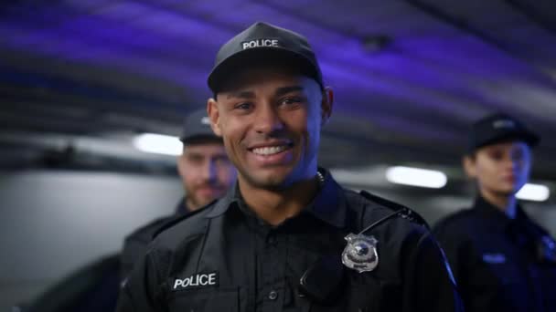 Un policía sonriendo a la cámara. Policía positivo en uniforme posando en la cámara — Vídeo de stock