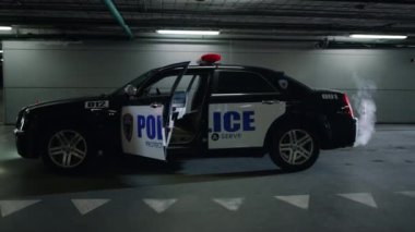 İnşaat binasında polis arabası park ediyor. Kapıları açık devriye aracı.