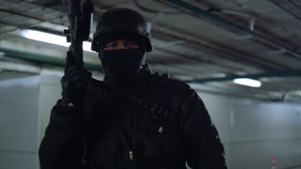 도시 건물에서 돌격소총을 들고 카메라 앞에 포즈를 취하는 SWAT 군인 — 비디오