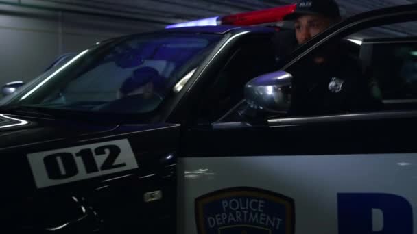 Polizeiteam steht vor einem Polizeiauto. Polizisten zielen mit Schusswaffen hinter Fahrzeug — Stockvideo