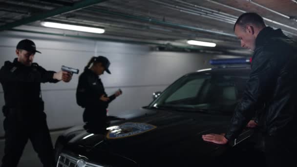 Oficiales de policía arrestando a ladrón. Hombre peligroso cogido de la mano en coche patrulla — Vídeo de stock