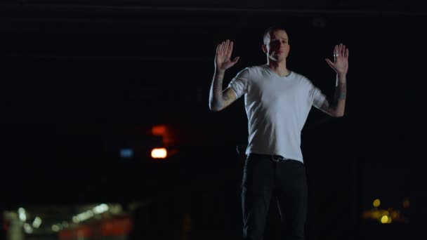 손을 들고 밤에 길 위에 서 있는 용의자. 총을 든 범죄 — 비디오