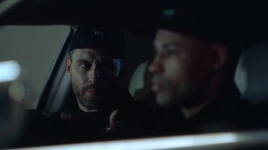 Devriye arabasında polisler görev başında. Polisler polis aracında konuşuyor.