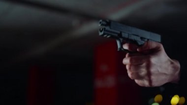 Adam elleri silahla ateş ediyor. Polis memuru parmağını tabancanın tetiğine bastırdı.