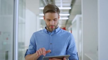 Ofiste tablet kullanan neşeli bir işadamı. İş adamı içeride çalışıyor..