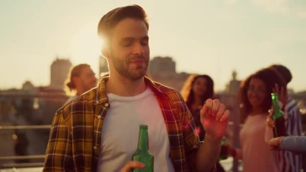 Joyeux mec prenant de la bière au coucher du soleil disco. Les gens multiethniques s'amusent à la fête. — Video