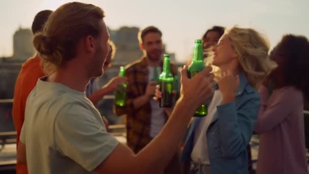 Boldog emberek élvezik a partit sörrel a szabadban. Barátok táncolnak a háztetőn. — Stock videók