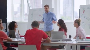 Zeki meslektaşlar takım liderinin ofisini dinliyor. İş adamı insanlarla konuşuyor.